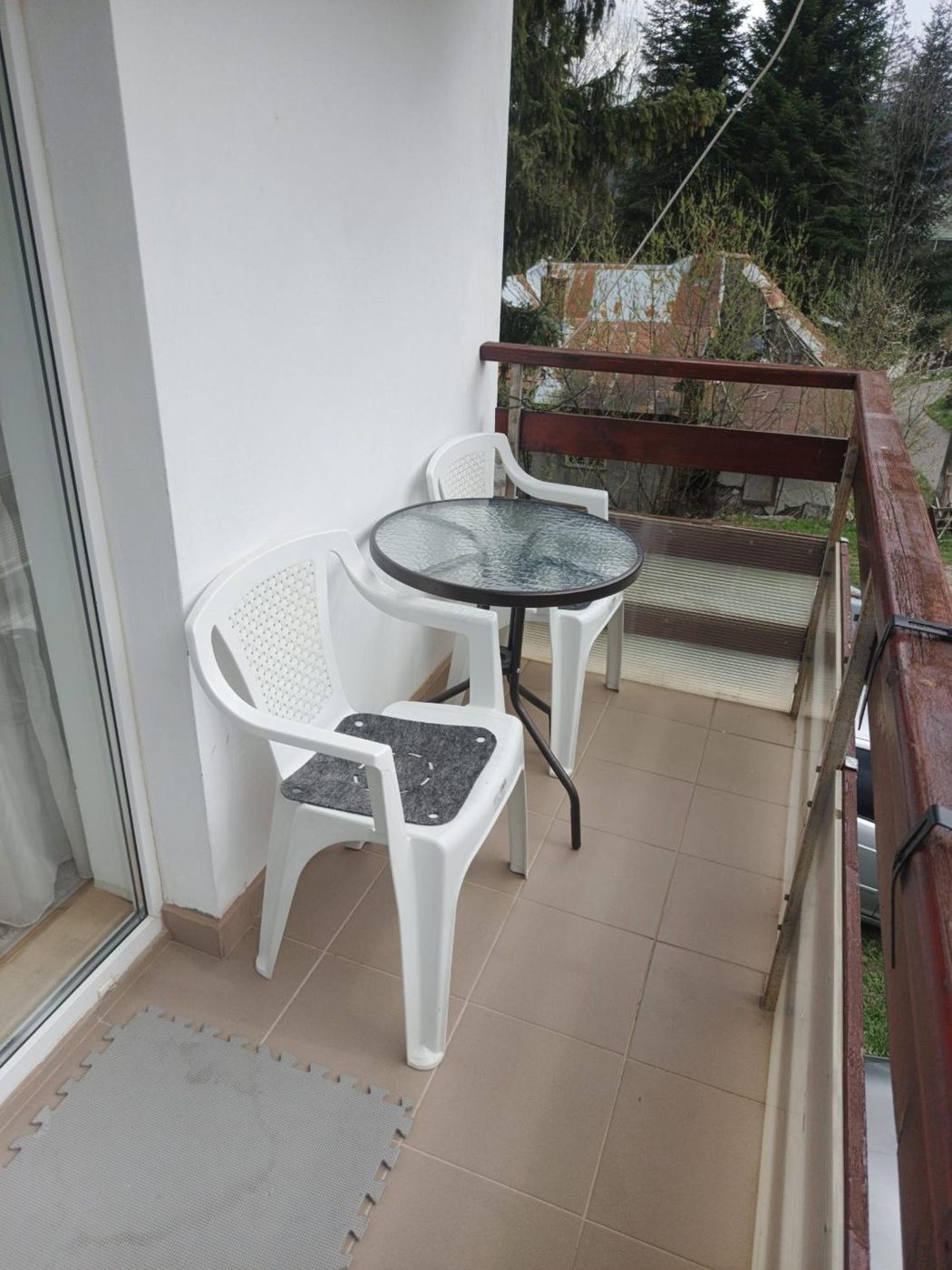 Balcon cu masă și scaune, cu vedere spre brazi